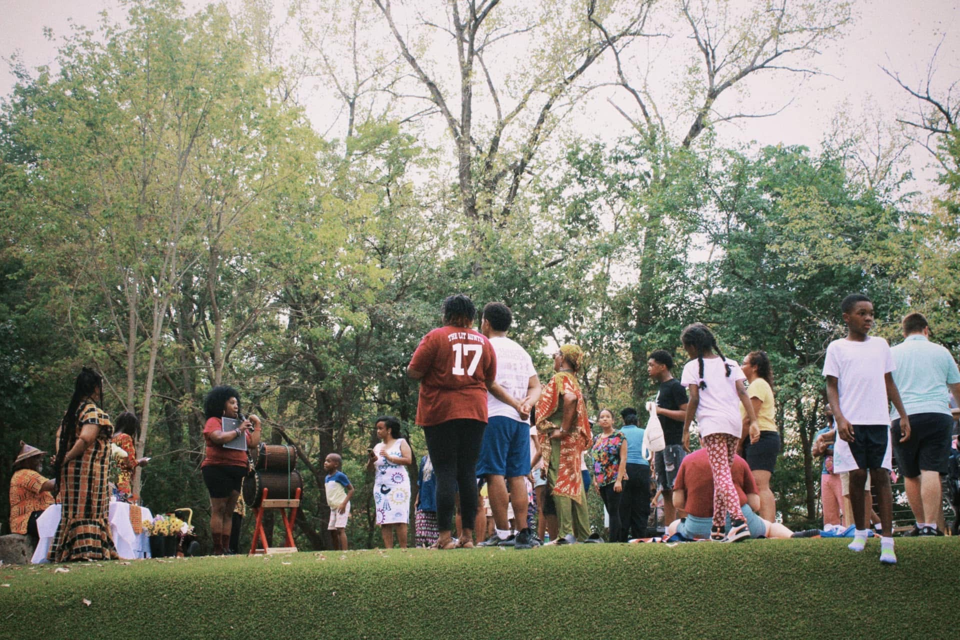 A wide crowd gathered on the green, listening to the call of the drums